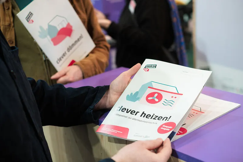 Zwei H&auml;nde halten eine Brosch&uuml;re mit dem Titel 