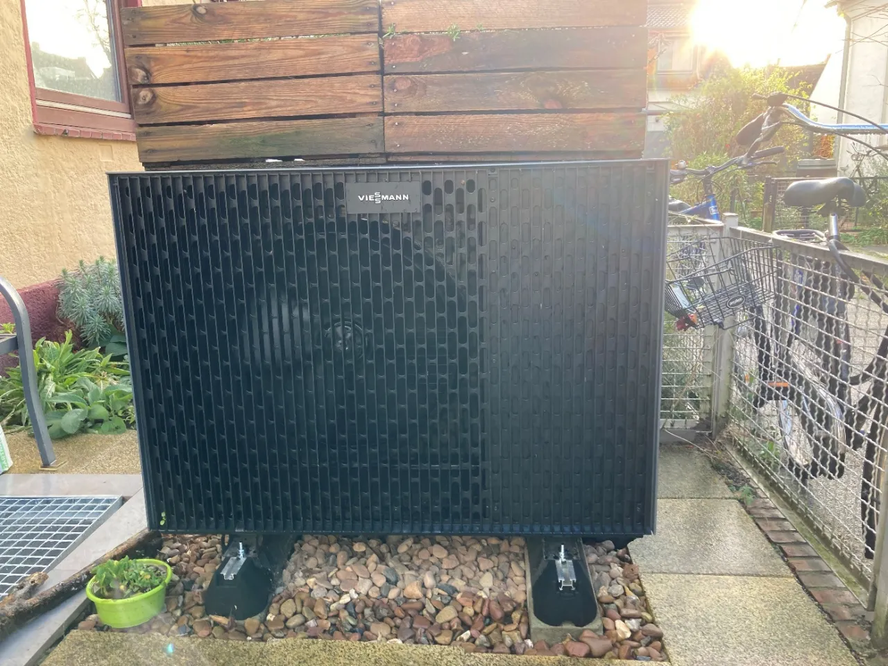 Eine schwarze Wärmepumpe vor einem Haus