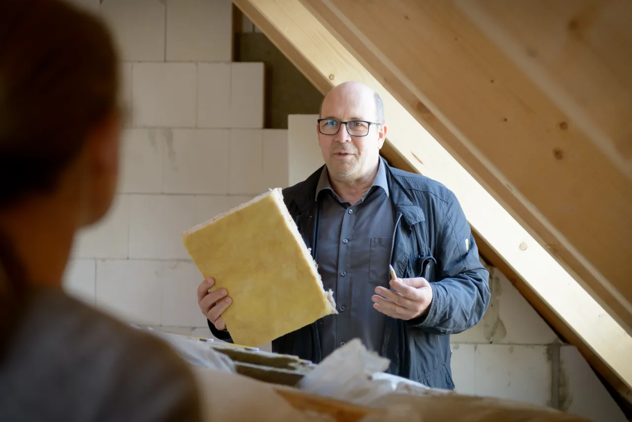Energieberater h&auml;lt D&auml;mmaterial in der Hand