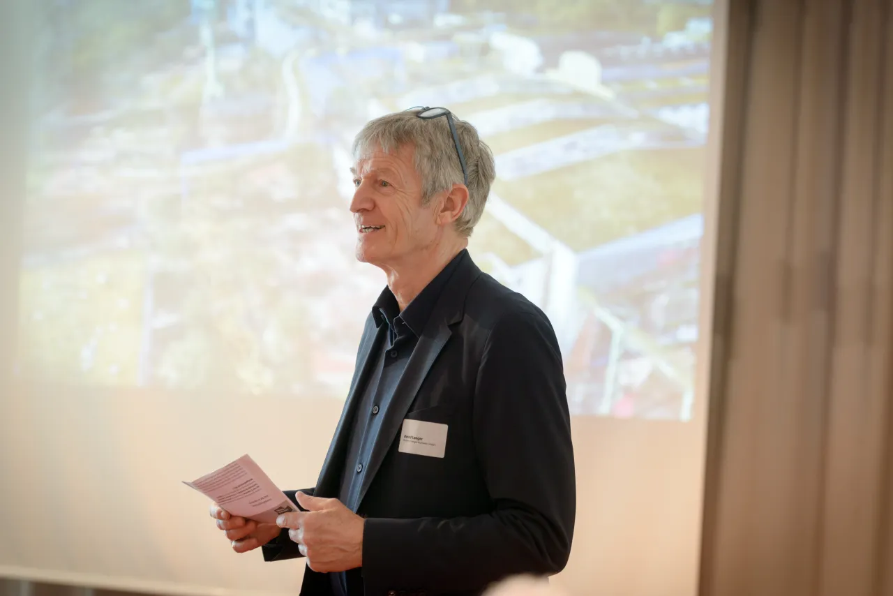 Mann steht vor Leinwand und h&auml;lt einen Vortrag