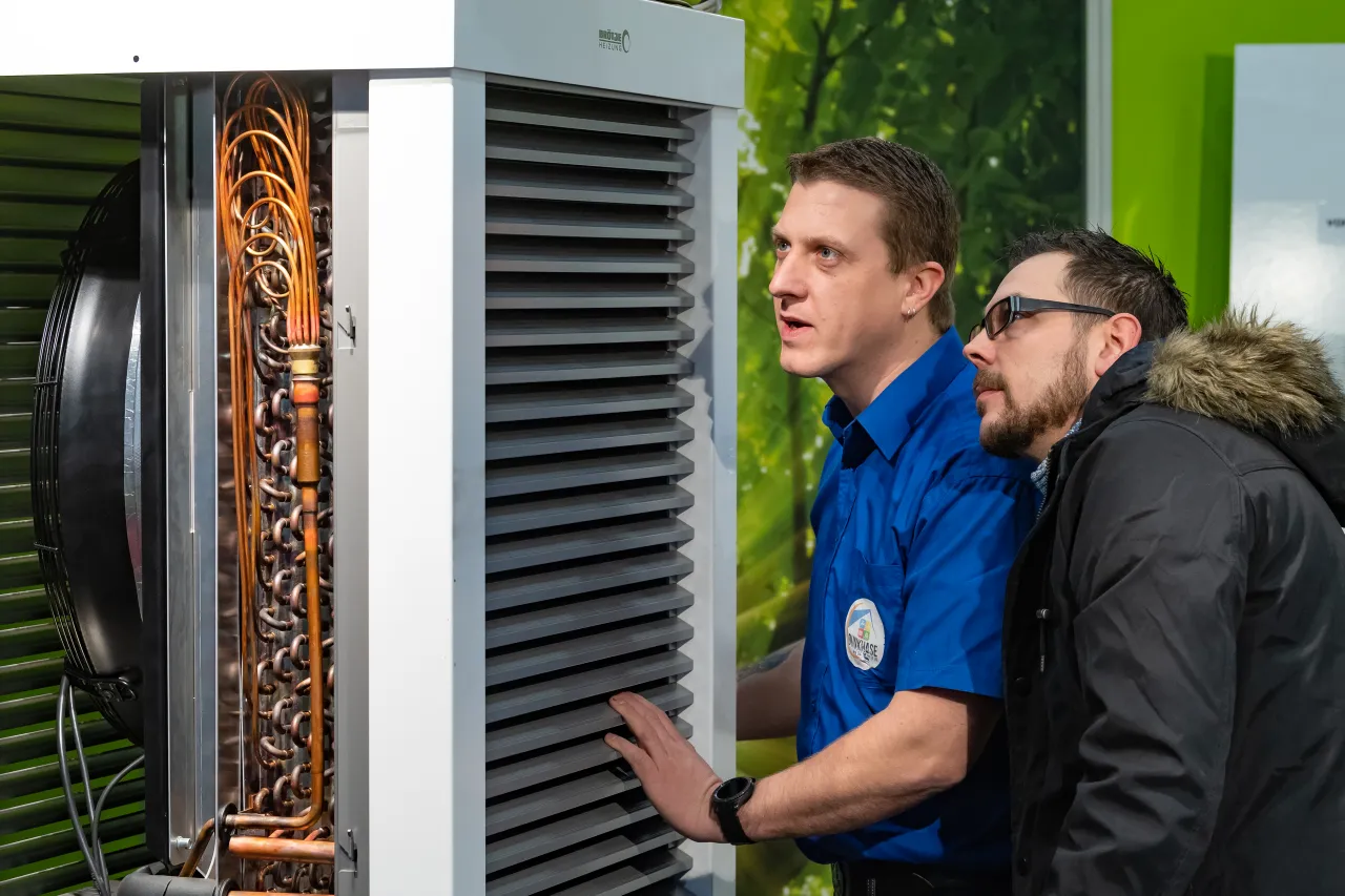 Beratungssituation vor Wärmepumpen-Ausstellungsstück auf den Bremer Altbautagen 2020