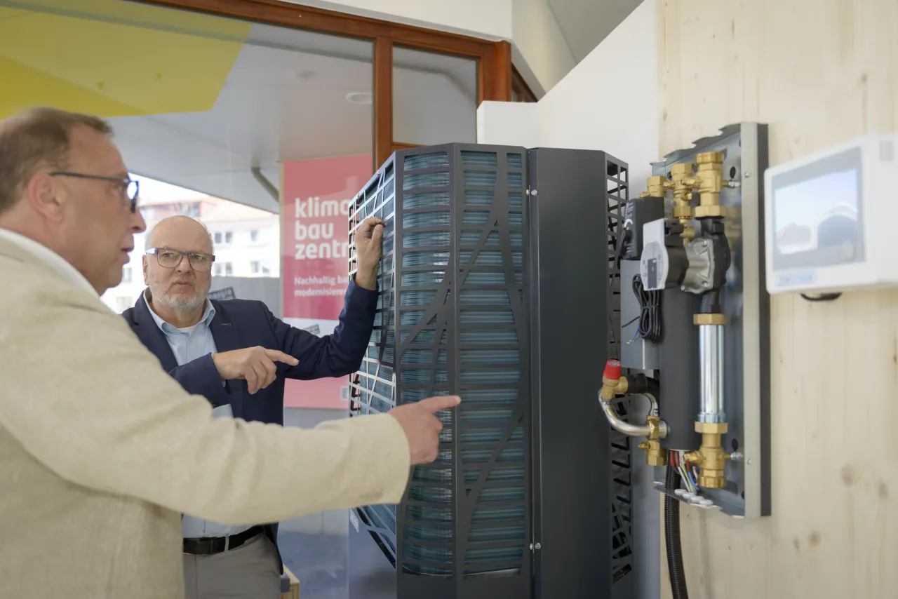 Beratung im Klima Bau Zentrum Bremerhaven zum Thema W&auml;rmepumpen - zwei M&auml;nner im Gespr&auml;ch an einer W&auml;rmepumpe