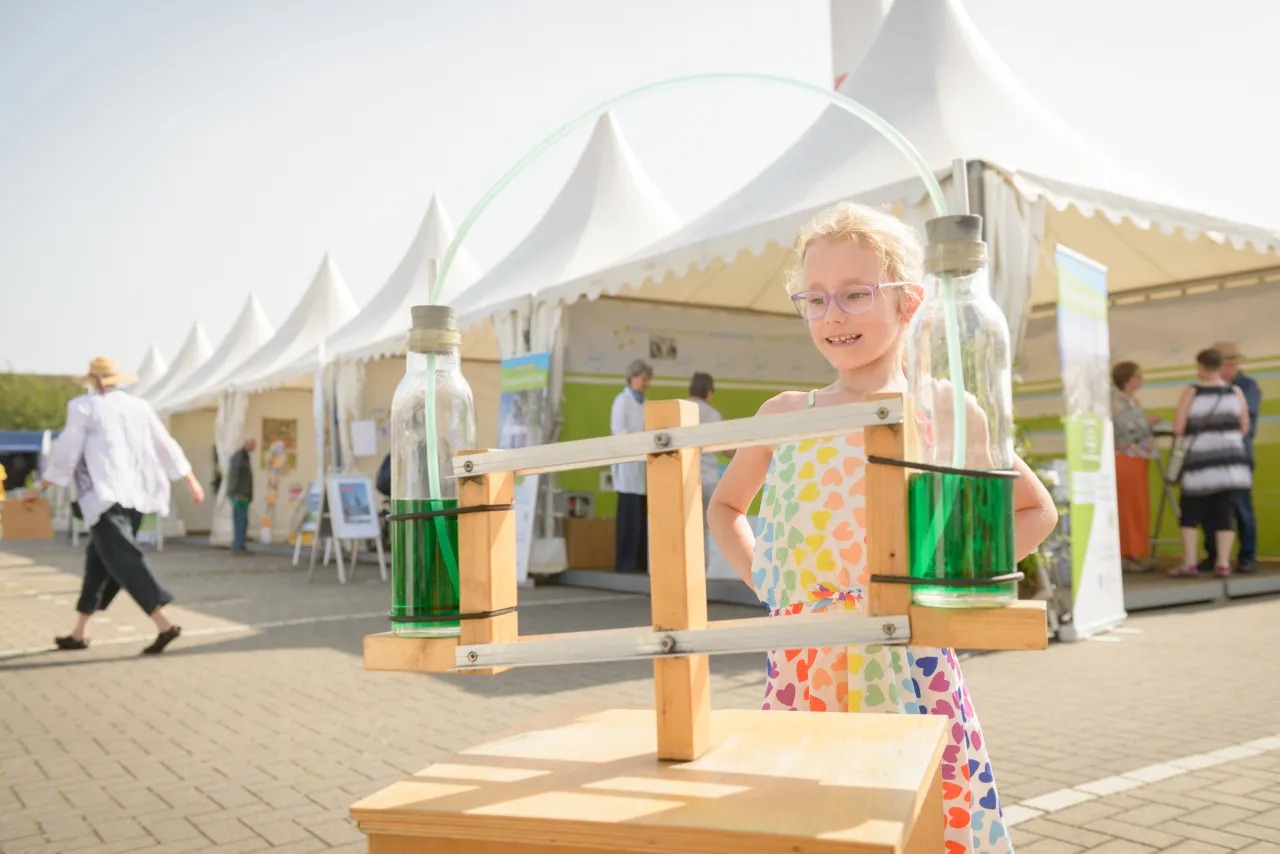 Kleines Mädchen vor einem Experiment beim Energie-und Klimastadttag