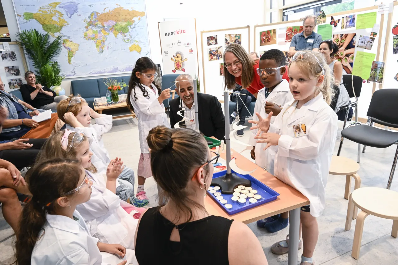 Kinder in Kitteln und mit Schutzbrillen beim Pressetermin zur ener:kita-Prämienvergabe.