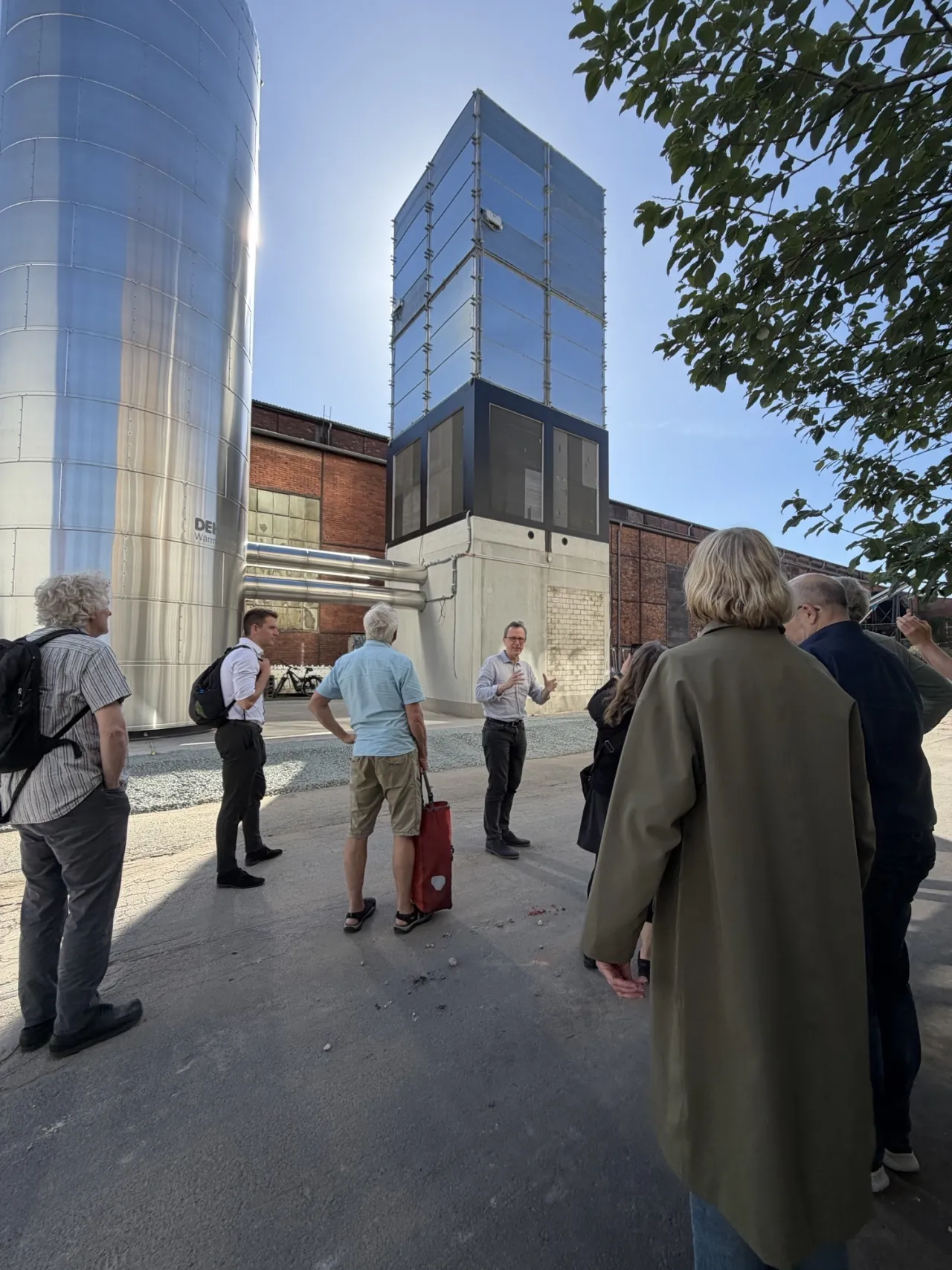 Gruppe von Menschen steht vor einem hohen Turm