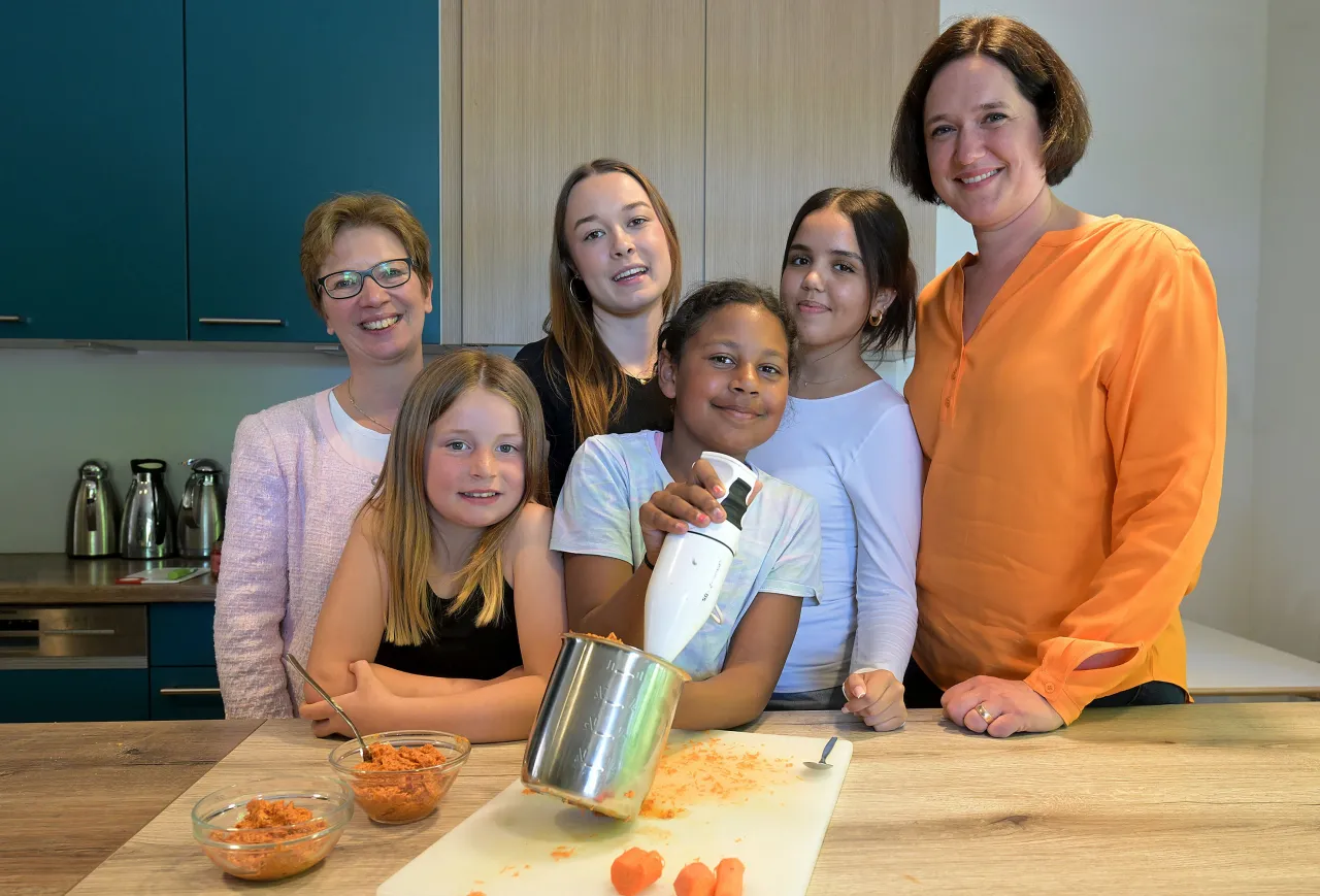 In einer gemeinsamen Aktion zur klimafreundlichen Ernährung bereiteten Lina-Marlen (Mitte v.l.), Kimberly, Georgina und Yasmin aus dem Jugendhaus Horn-Lehe zusammen mit Sozialsenatorin Dr. Claudia Schilling (l.) und Umweltsenatorin Kathrin Moosdorf (r.) einen veganen Brotaufstrich zu. (c) ener:freizi / m.bahlo