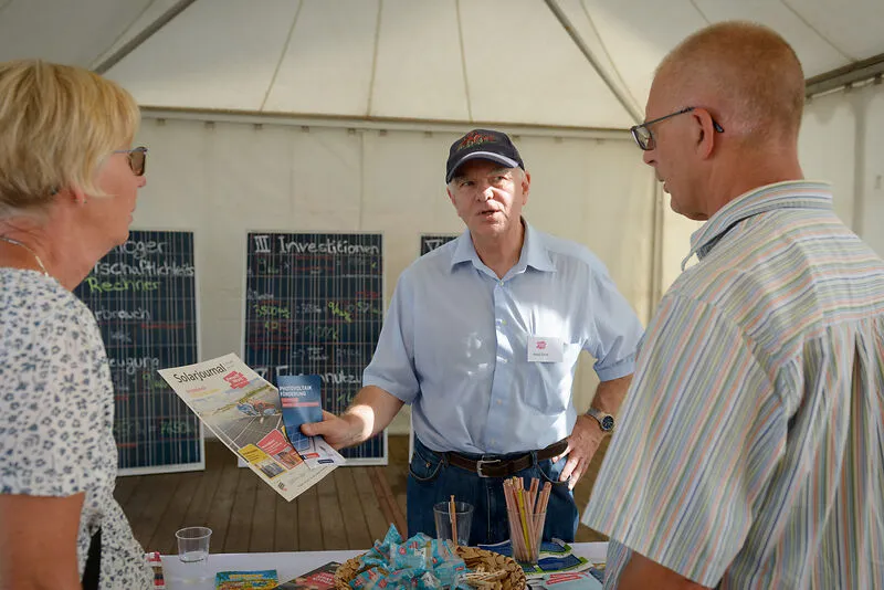 Eine Frau und ein Mann lassen sich an einem Infostand zum Thema Solar beraten.
