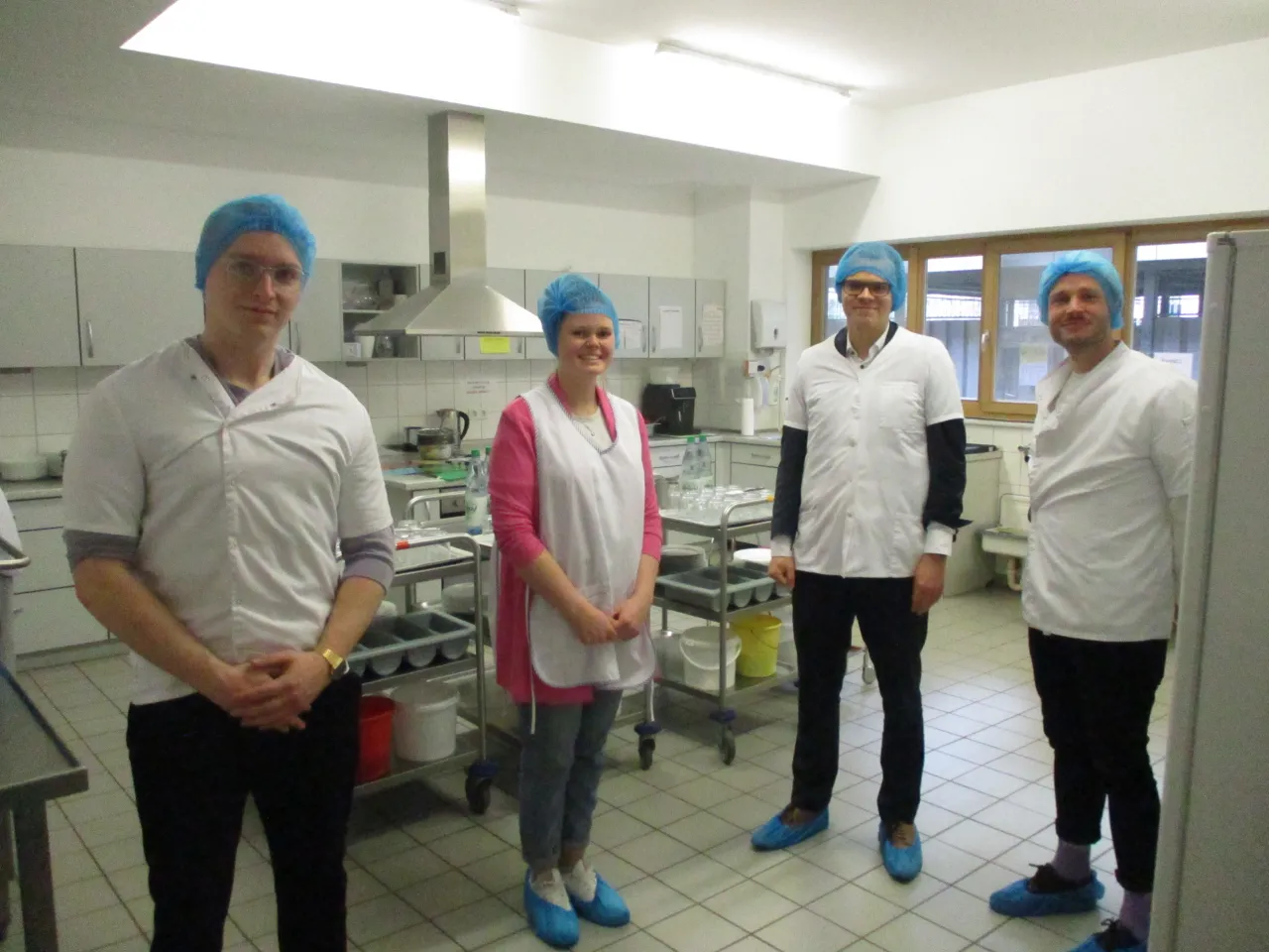 Staatsrat Jan Fries steht neben Küchenpersonal der Hans-Went-Kitas