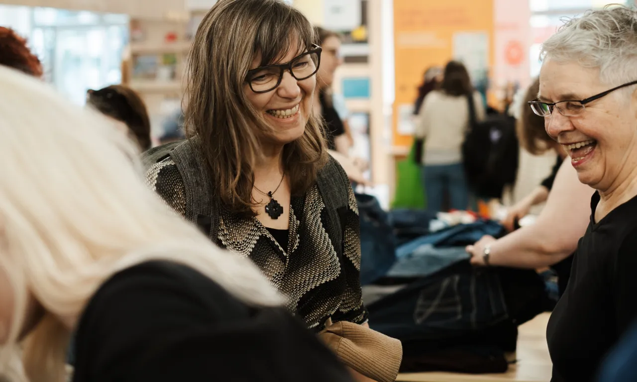 Zwei lächelnde Frauen auf einer Kleidertauschparty