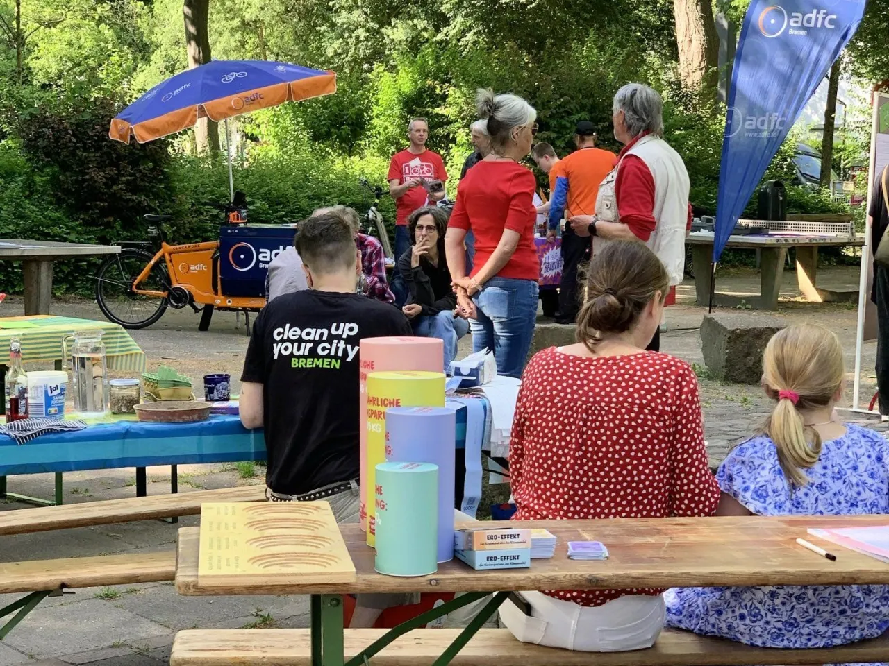 Besucher*innen des Klimatages in Klein-Mexiko sitzen auf Bierbänken.