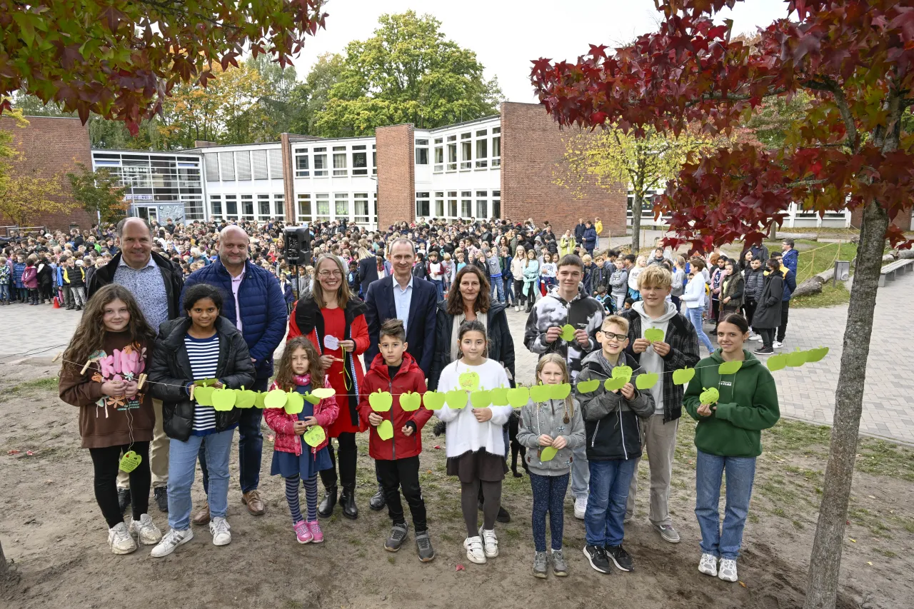 Zum Auftakt des Projektes „Schulen auf dem Weg zur Klimaneutralität“ hängen Schülerinnen und Schüler gemeinsam mit Bildungssenatorin Sascha Karolin Aulepp, Klimaschutzwünsche auf dem Schulcampus der Wilhelm-Focke-Oberschule und Marie-Curie-Grundschule auf. Ebenfalls dabei (v.l.n.r.): Lars Beulke (Schulleiter Grundschule am Baumschulenweg), Wolfgang Kirst (Schulleiter der Wilhelm-Focke-Oberschule), Martin Grocholl (Geschäftsführer der Klimaschutzagentur energiekonsens) und Andrea Barthe (Schulleiterin der Marie-Curie-Grundschule); (Foto: energiekonsens, Fotograf: Karsten Klama)