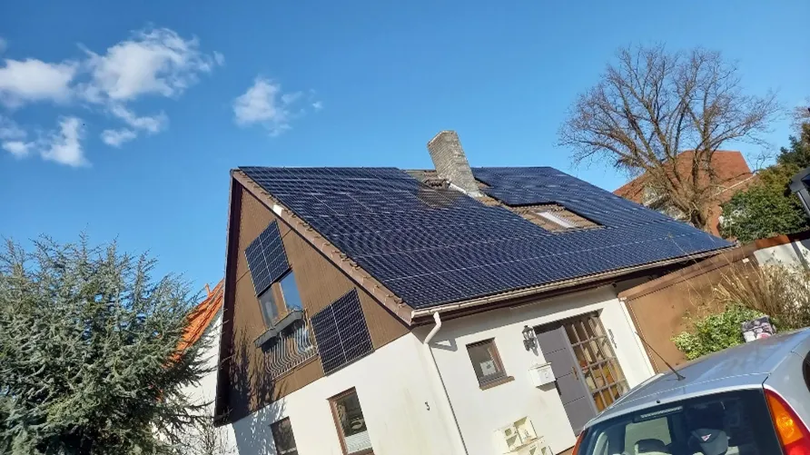 Außenansicht eines Einfamilienhauses mit PV-Anlage auf dem Dach.
