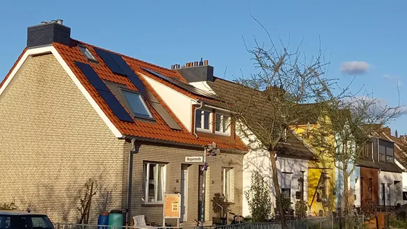 Die Au&szlig;enansicht eines Reihenendhauses mit PV-Anlage auf dem Dach