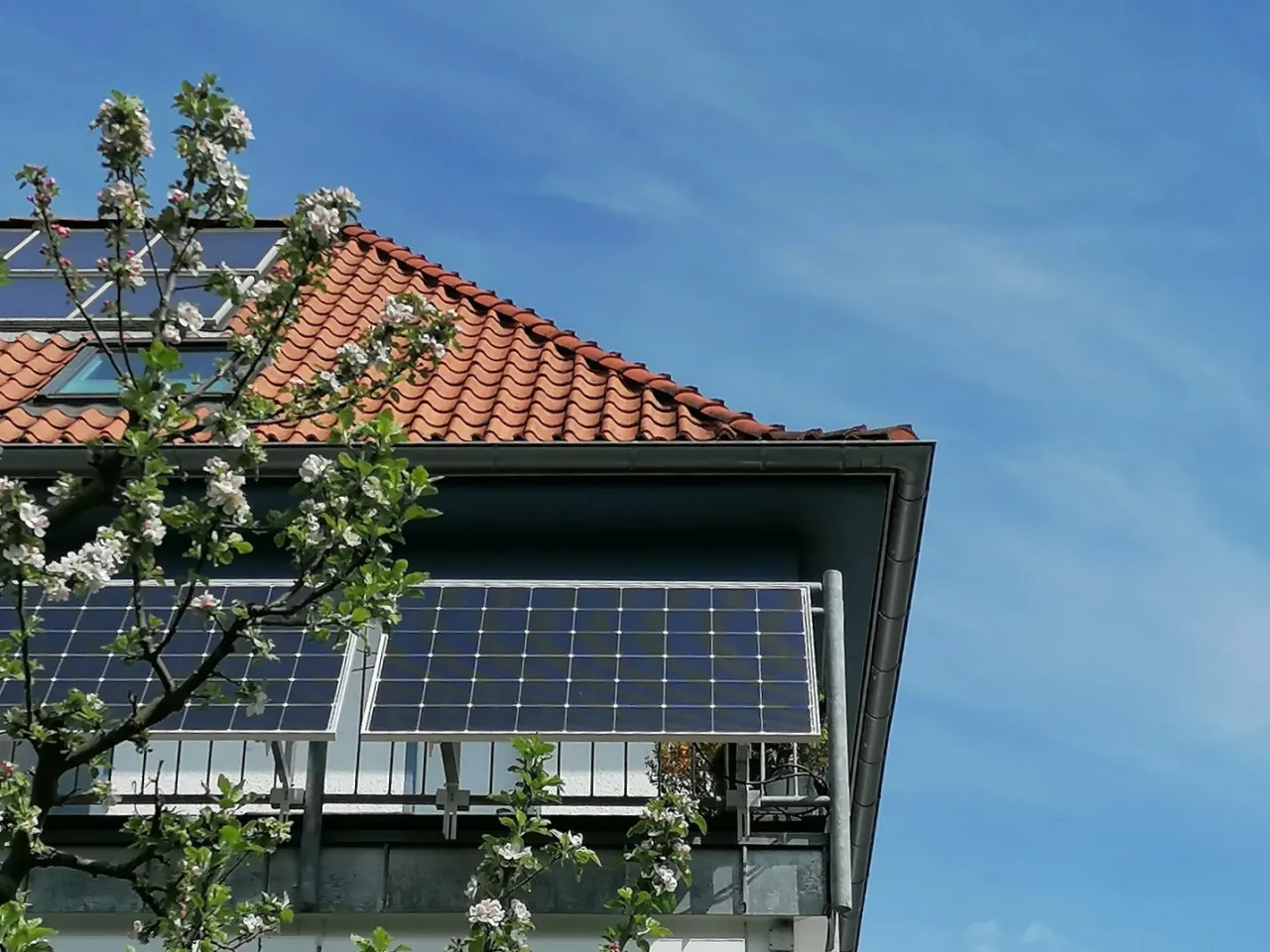 Ein Haus mit Steckersolar am Balkon bei sch&ouml;nem Wetter