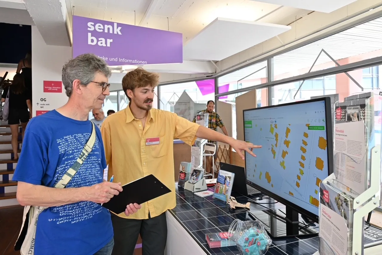 Ein Beratungsgespr&auml;ch am Solarkataster im Klima Bau Zentrum Bremen. Ein Mann zeigt auf den Bildschirm und erkl&auml;rt einem anderen, was dort zu sehen ist.