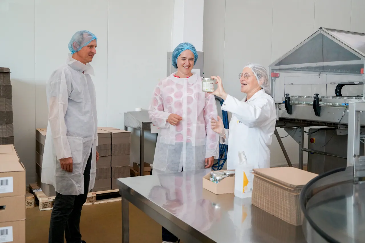 Drei Personen in Kittel und mit Haarhaube