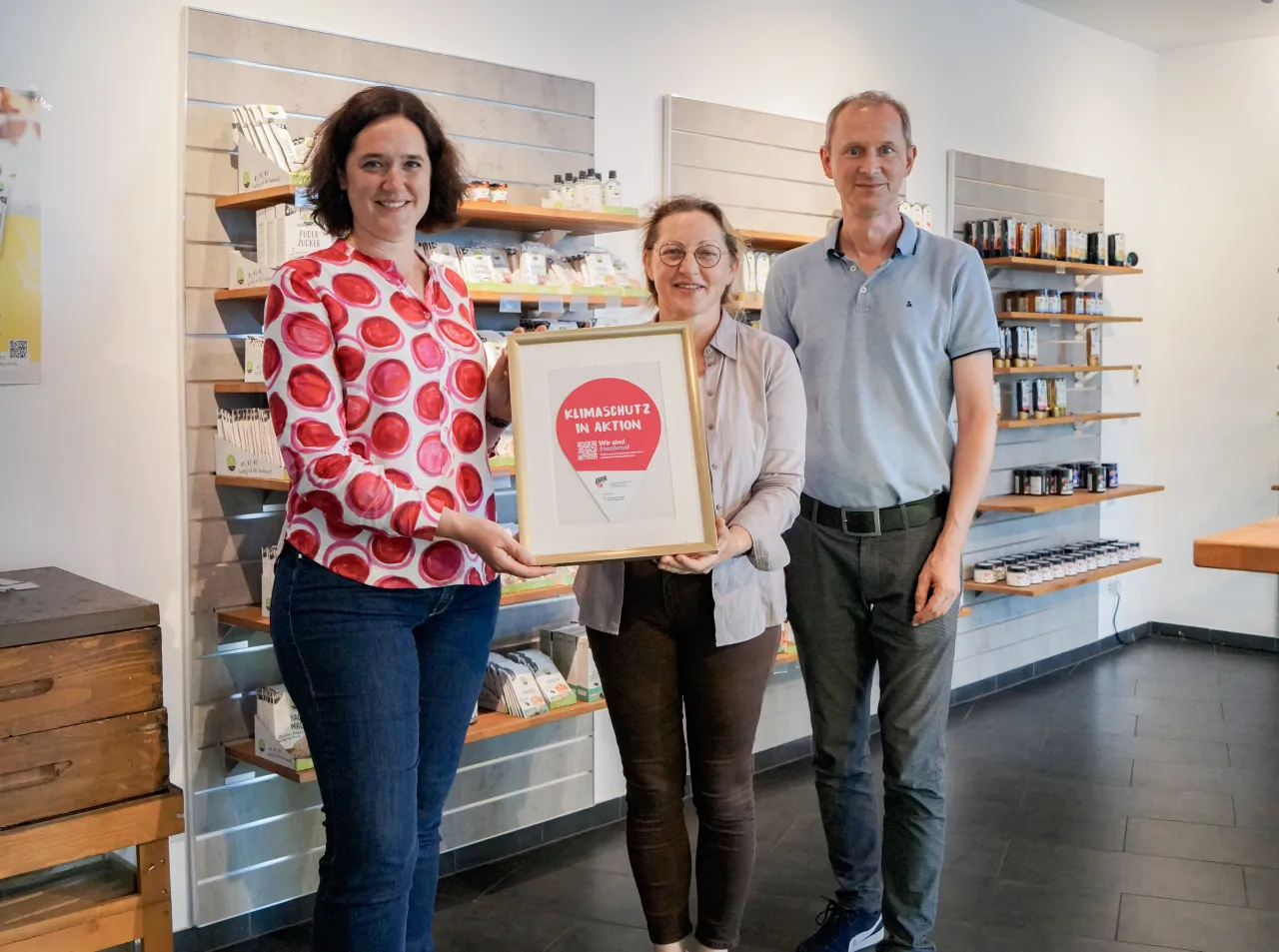 Drei Personen halten Auszeichnung