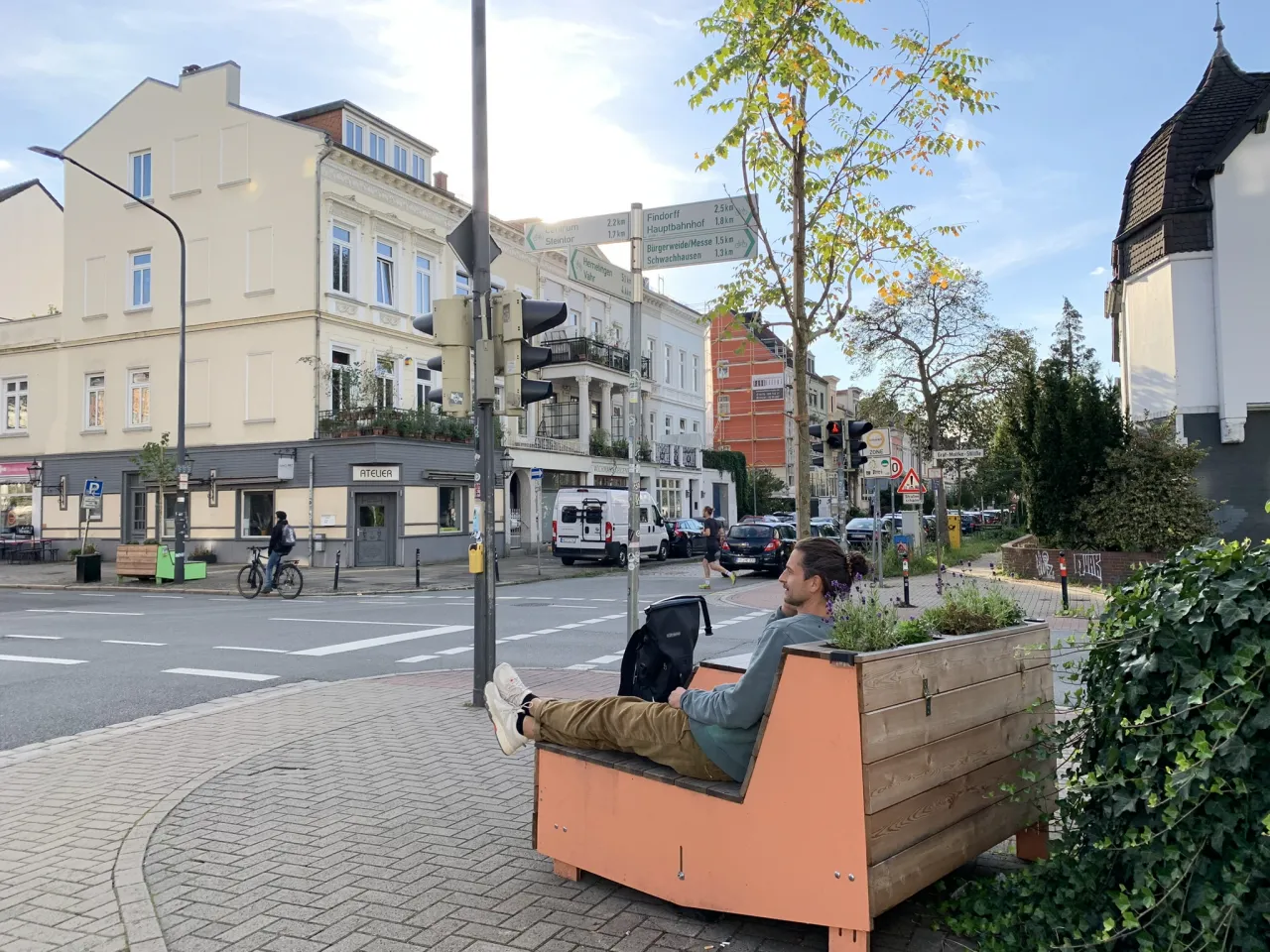 Mann sitzt auf einer bepflanzten Bank an einer Kreuzung in Bremen