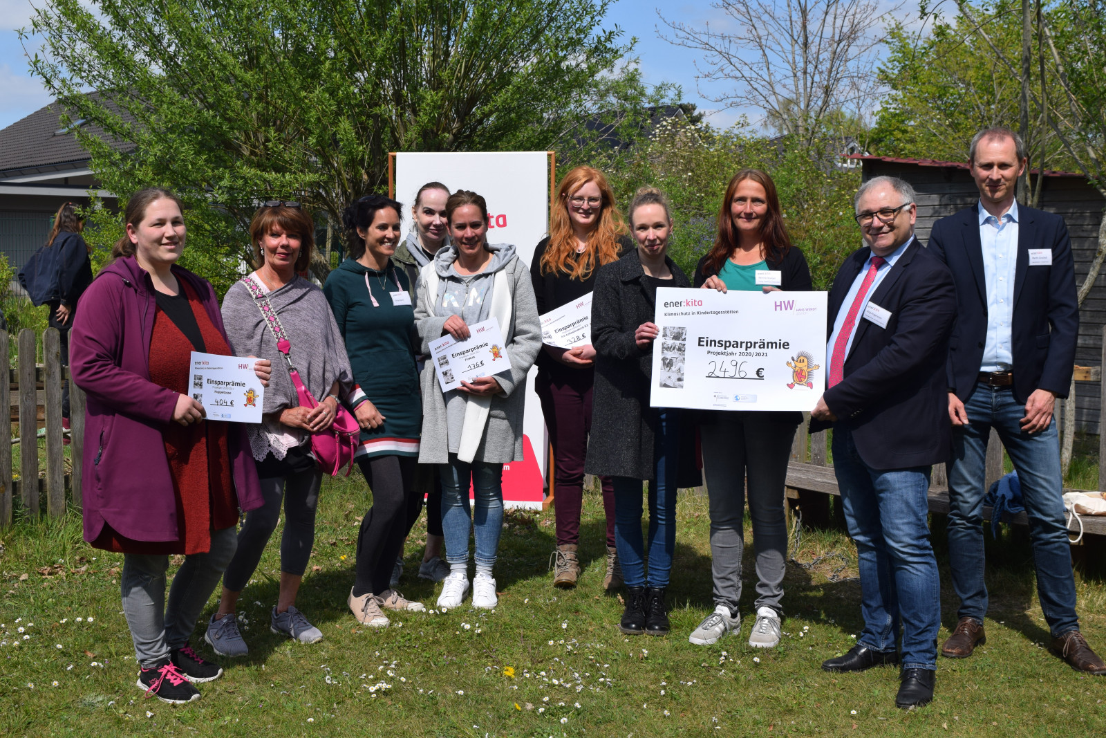 Gruppenfoto - Jörg Angerstein, Geschäftsführer der Hans-Wendt gGmbH und energiekonsens-Geschäftsführer Martin Grocholl übergeben Check an die Leiterinnen der Hans-Wendt-Kitas