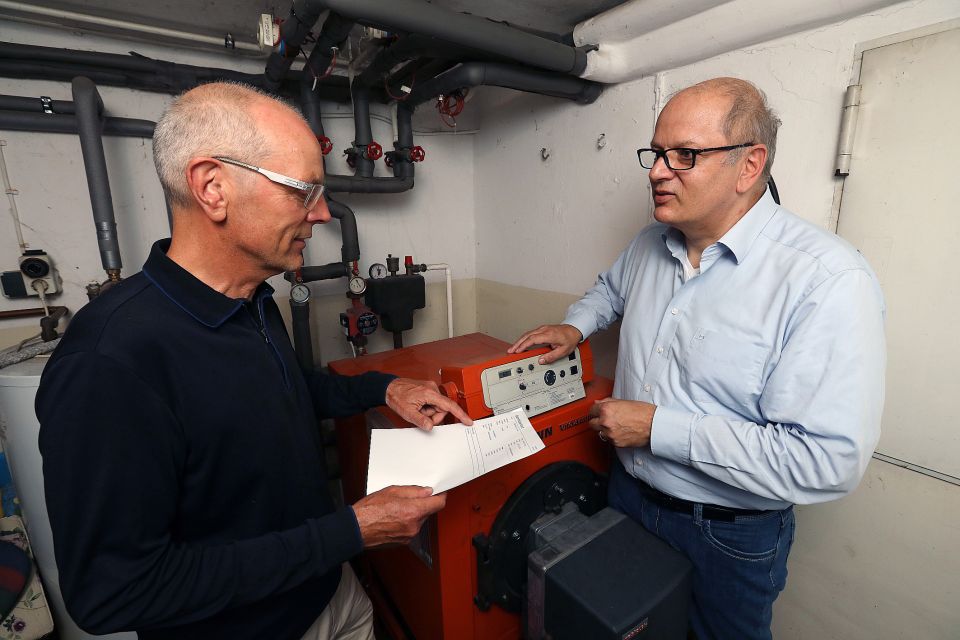Heinfried Becker (energiekonsens) und Rainer Mathia (SKUMS) vor alter Ölheizung