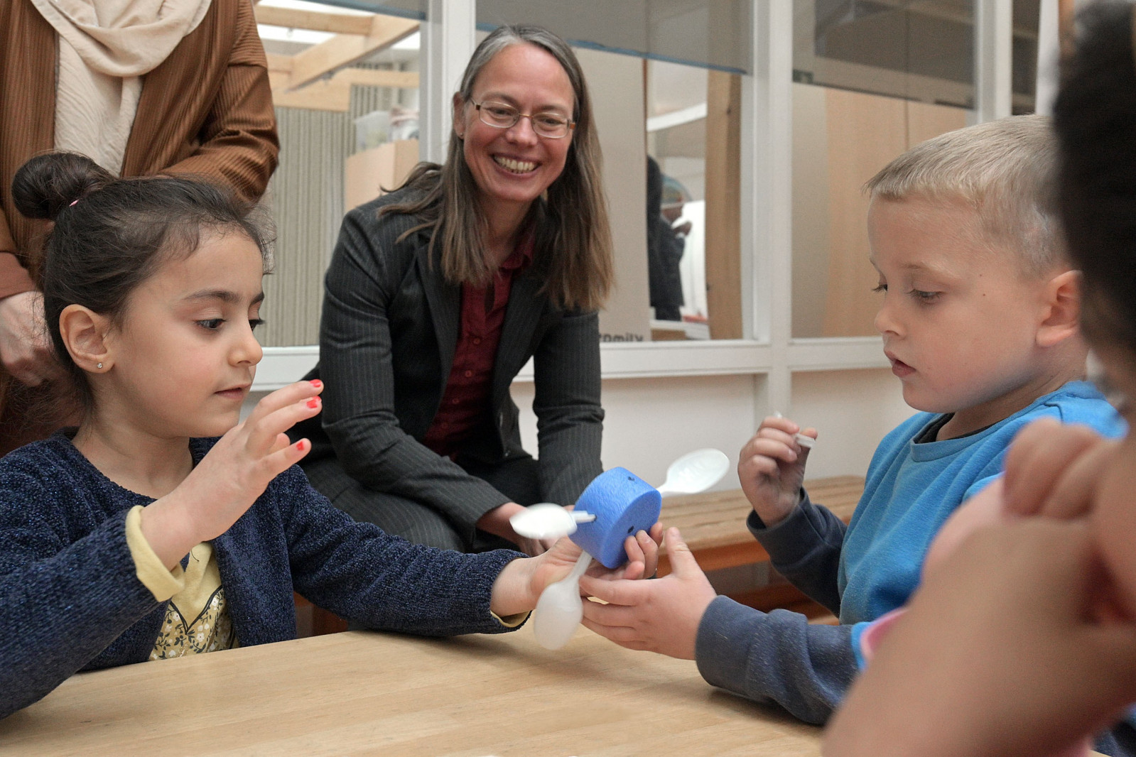 Bildungssenatorin Sascha Aulepp beobachtet wie zwei Kinder ein Experiment durchführen