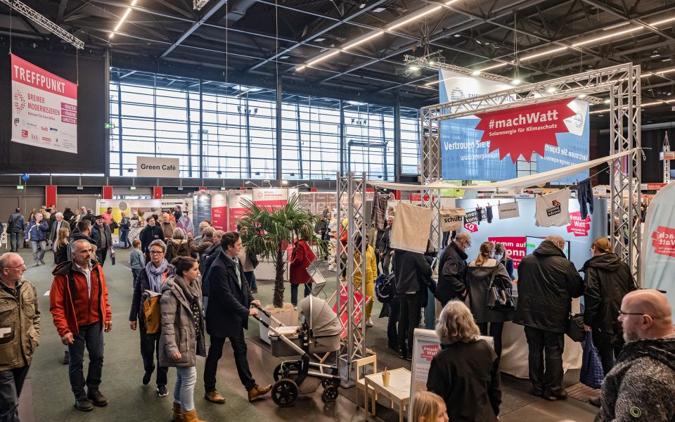 Blick von schräg oben auf den Solarstand auf den Bremer Altbautage - viele Personen stehen und Laufen in der Halle 7