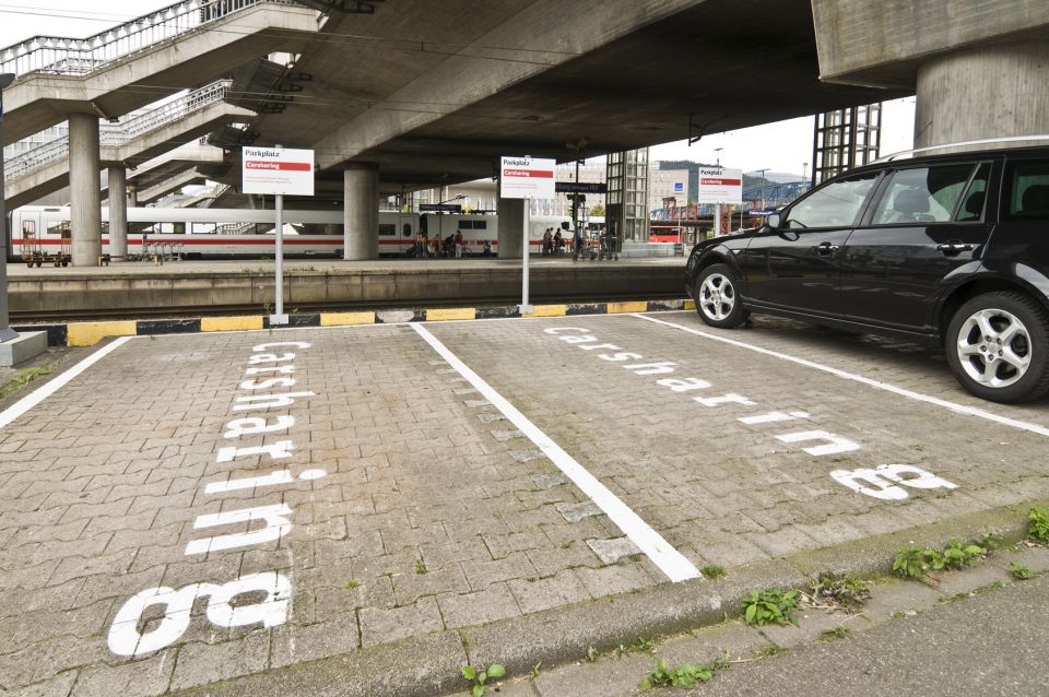 Auto steht auf Parkplatz, daneben zwei lehre Parkflächen mit der Aufschrift