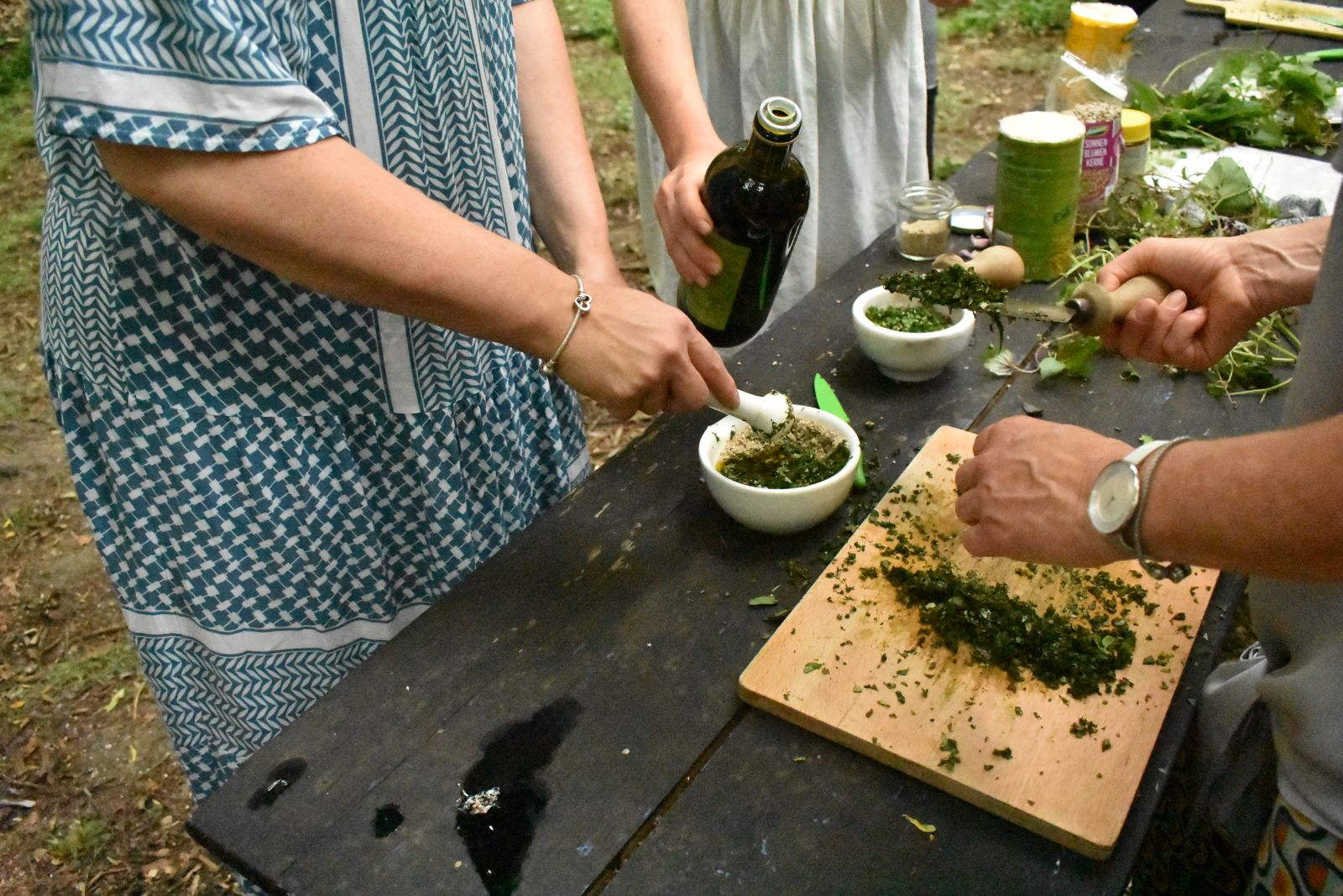 Hände verarbeiten Kräuter zu Pesto