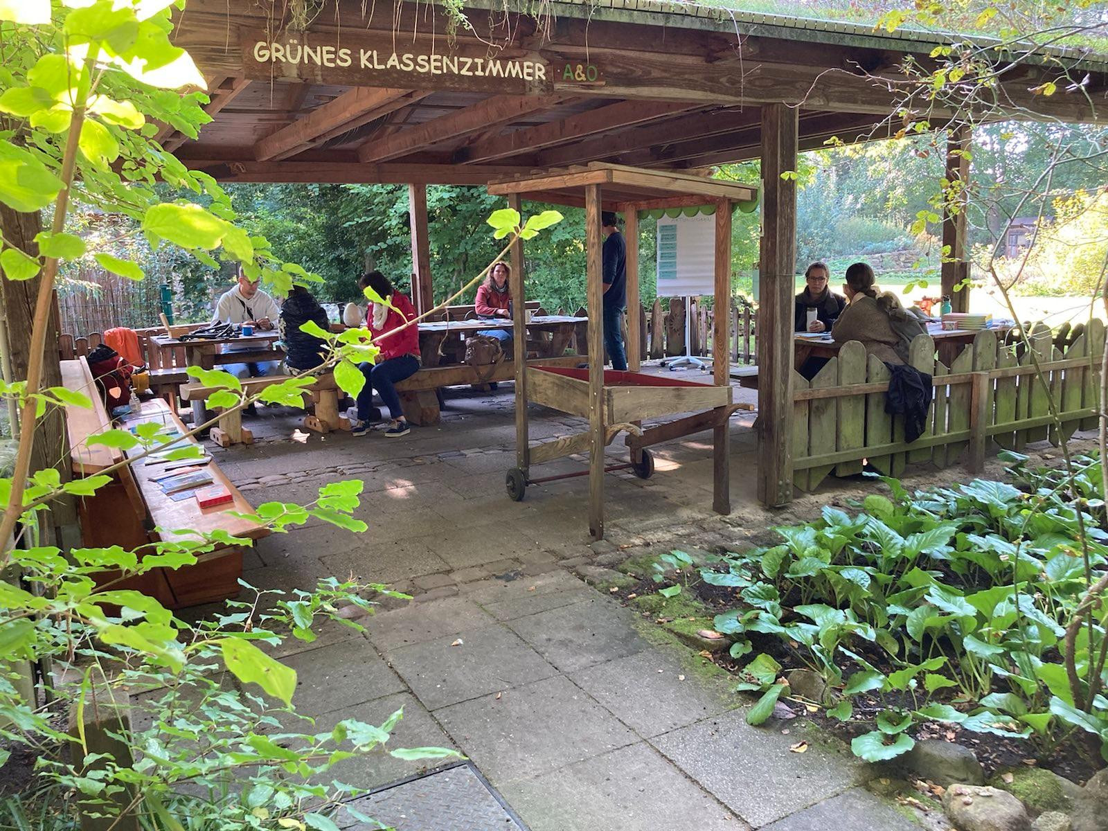 Gruppe sitzt auf überdachter Terrasse