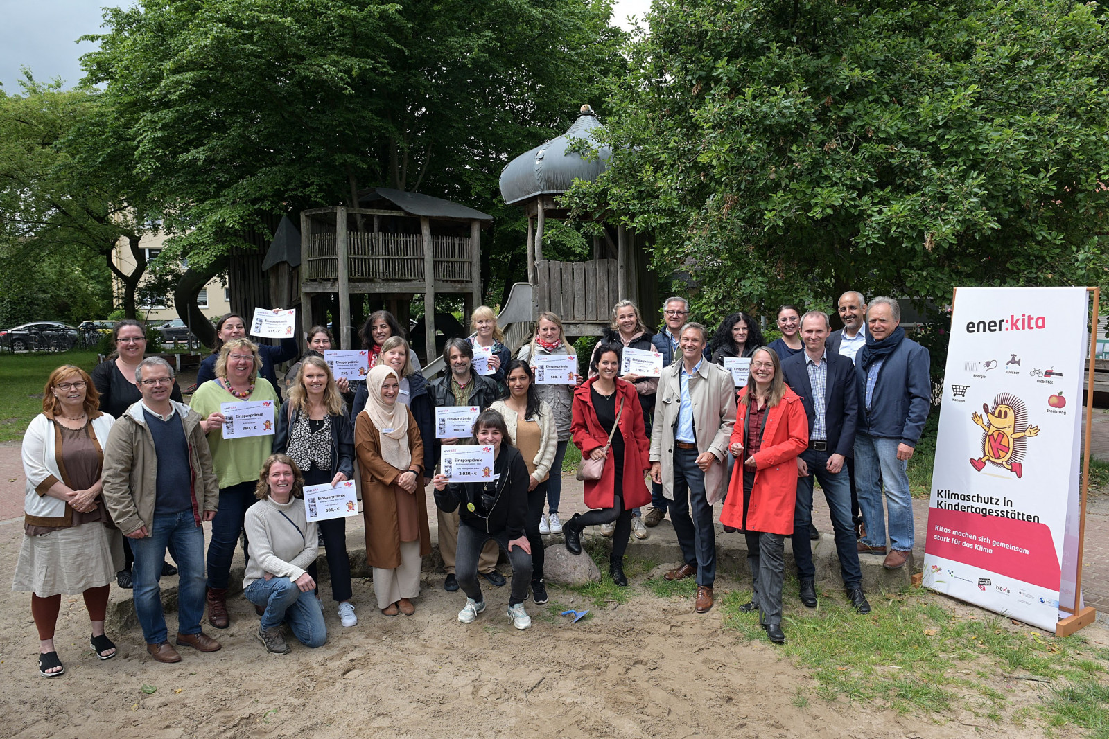 Gruppenbild Erzieher*innen bei Prämienübergabe, halten Prämienschilder in der Hand