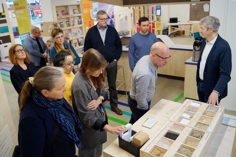 Personengruppe steht um ein Ausstellungsstück im Klima Bau Zentrum herum