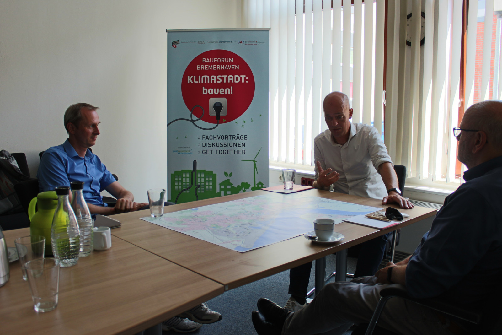 Michael Labetzke spricht mit Martin Grocholl und Heinfried Becker im energiekonsens Büro in Bremerhaven