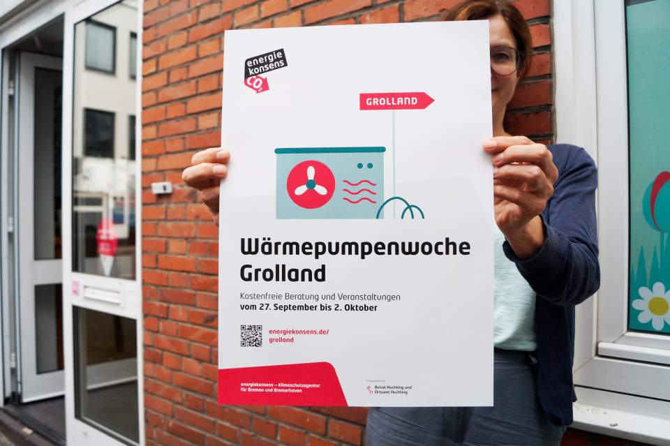 Person hält Plakat zur Wärmepumpenwoche in Grolland hoch