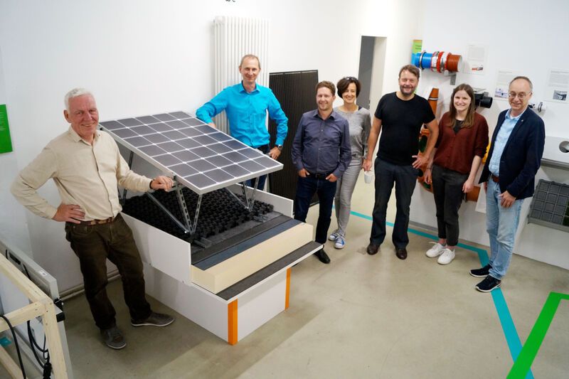 Menschen stehen um ein Solarmodul im Klima Bau Zentrum