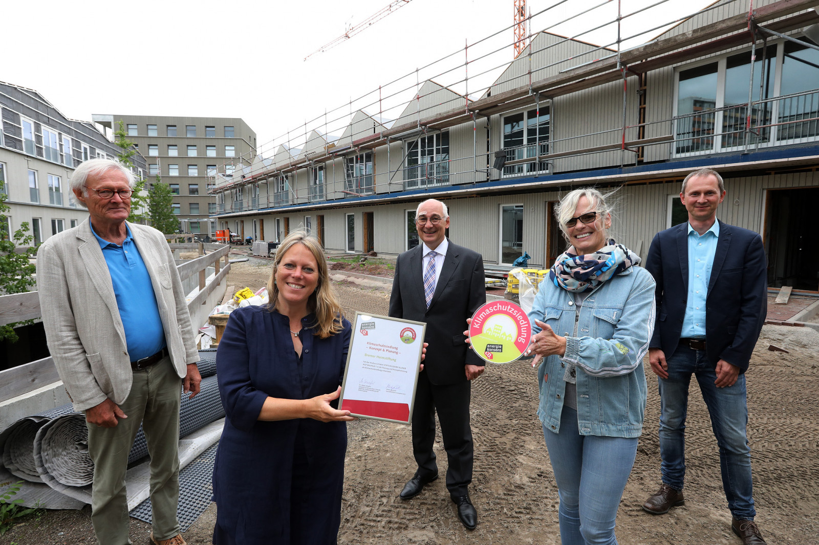 Senatorin Maike Schaefer zeichnet Ellener Hof als Klimaschutzsiedlung aus, Gruppenbild vor Baustelle